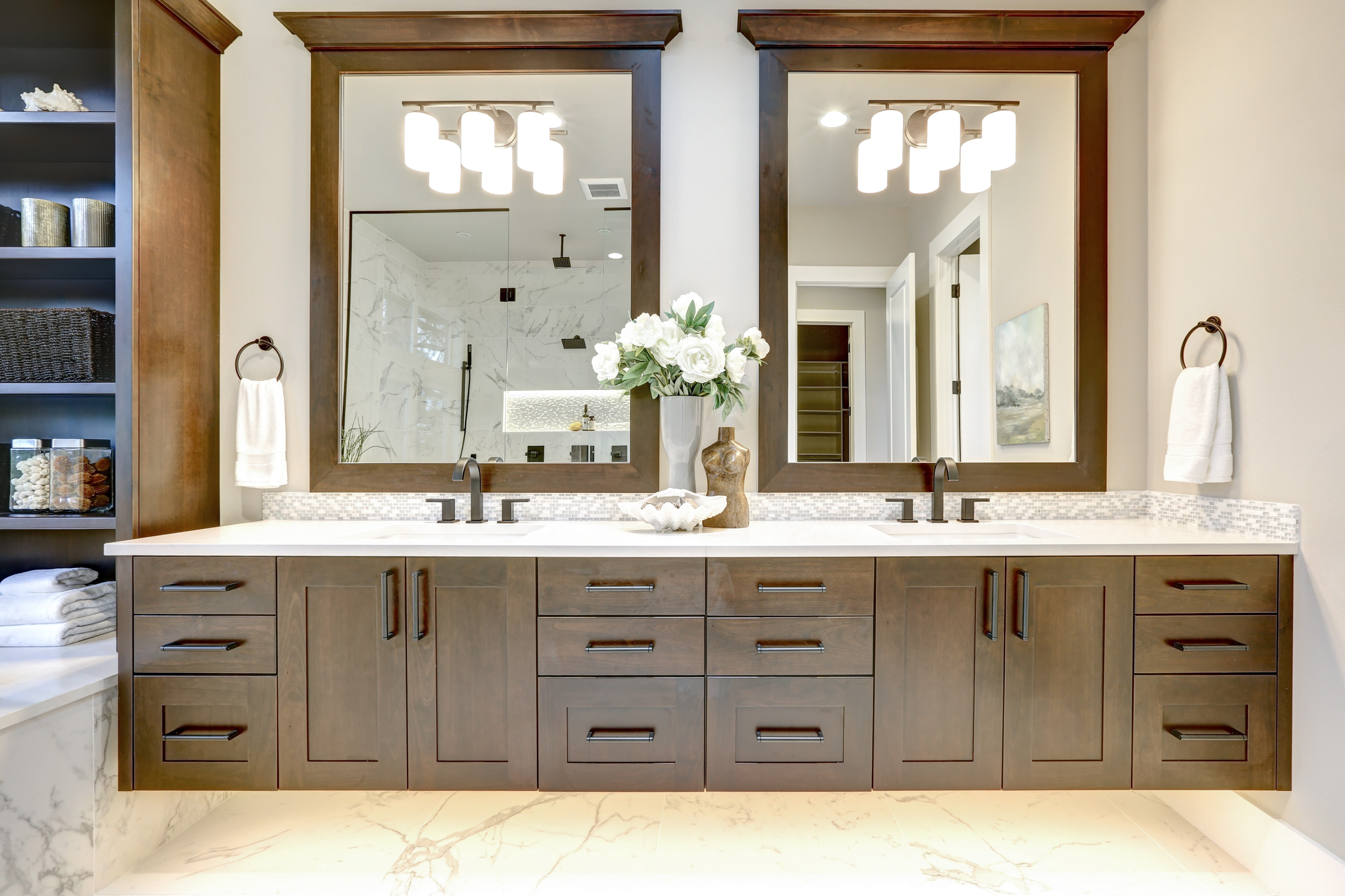 Master bathroom interior in luxury modern home with dark hardwood cabinets, white tub and glass door shower | Pierce Flooring